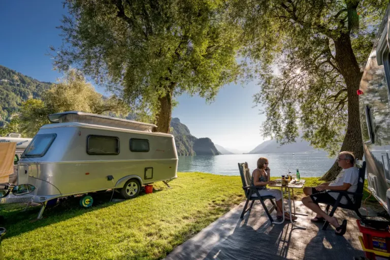 Aelteres Paar isst in der Abendsonne an einer Seeparzelle direkt am Brienzersee